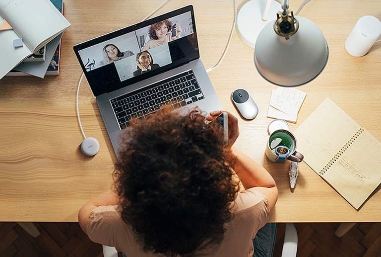 Eine Frau arbeitet an einem Computer und nutzt „Plug and Wireless“, um an einer Telefonkonferenz teilzunehmen.